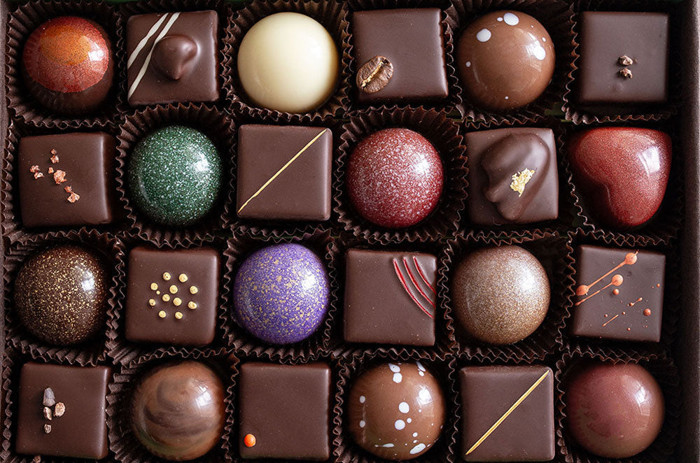 Assorted cocoa wilds chocolates in a box on a marble surface
