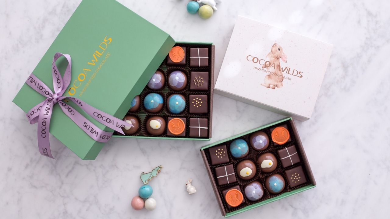 Beautiful Easter chocolate box assortments in twelve and twenty four piece configurations with lilac ribbons and metallic gold Cocoa Wilds Easter branding
